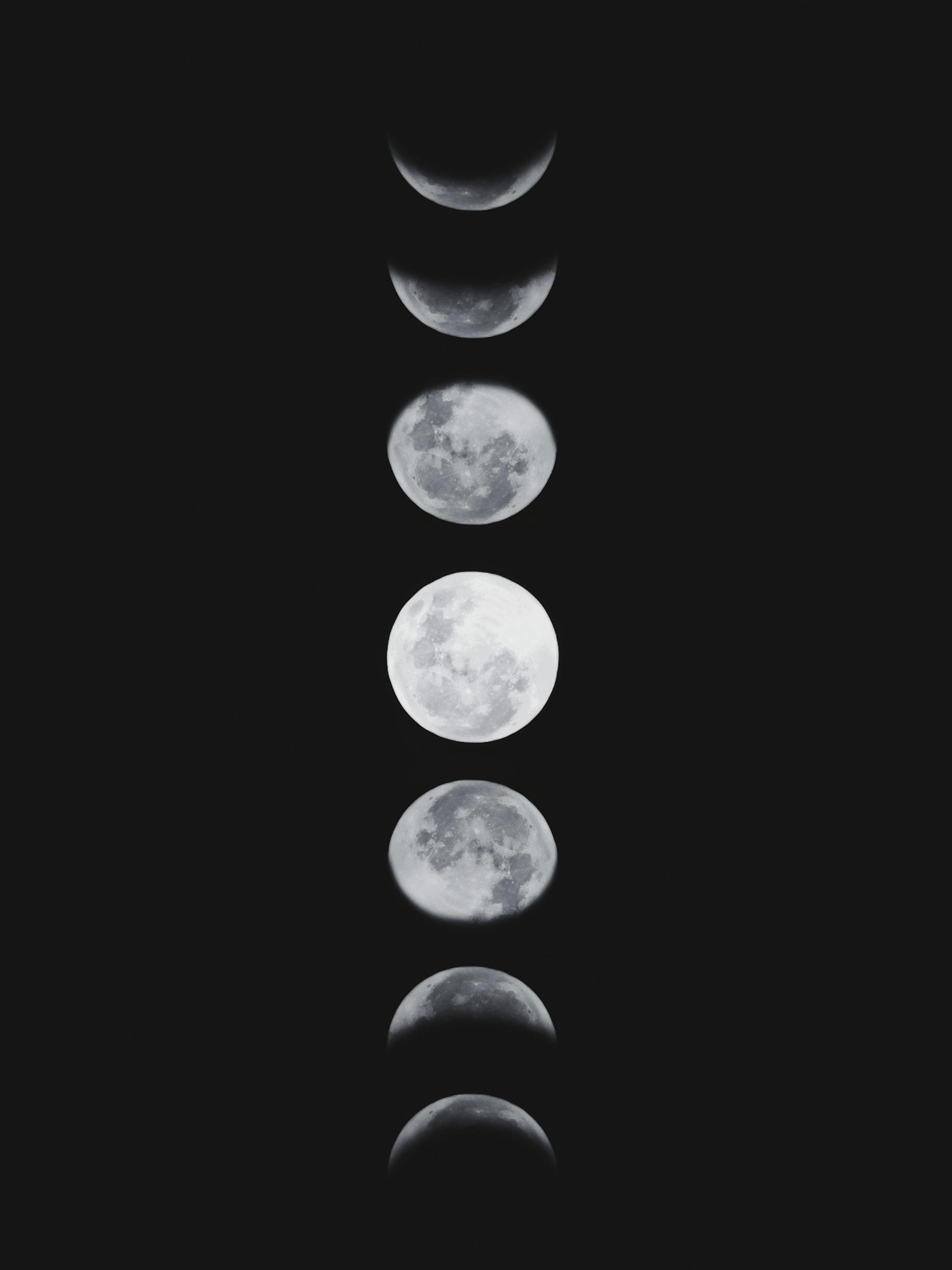 A vertical sequence of the moon's phases against a dark sky.