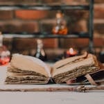 Close-up of a wooden wand and ancient spell book in a mystical, rustic environment.